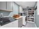 Well-organized laundry room with modern appliances, ample storage, and gray cabinets at 6890 Cedar Mountain Rd, Douglasville, GA 30134