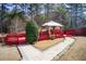 View of a red wooden deck and pathway surrounded by mature trees and landscaping at 1832 Millstone Mnr, Conyers, GA 30013