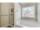 A well lit soaking tub with window and separate shower at 1832 Millstone Mnr, Conyers, GA 30013