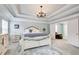 Main bedroom with decorative chandelier, crown molding and sitting area at 1832 Millstone Mnr, Conyers, GA 30013