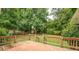 Large backyard featuring a wooden deck, well-maintained lawn, and mature trees at 411 Burke Cir, Mcdonough, GA 30253