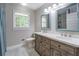 Bathroom featuring a double vanity, modern fixtures, and natural light from the window at 411 Burke Cir, Mcdonough, GA 30253