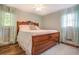 Comfortable bedroom featuring wood floors, blue curtains, and a large bed at 411 Burke Cir, Mcdonough, GA 30253