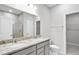 Bathroom featuring double vanity, granite countertop, large mirror, and tiled shower with glass door at 159 Park Lane Ln, Fairburn, GA 30213