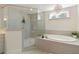 Luxurious bathroom showcasing glass shower, soaking tub, chandelier, and modern fixtures at 200 Bexley Pkwy, Tyrone, GA 30290