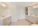 Bright bathroom featuring double sinks, white cabinets, large mirrors, and tile floors at 200 Bexley Pkwy, Tyrone, GA 30290