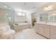 Elegant bathroom featuring a glass shower, soaking tub with chandelier, and white double sink vanity at 200 Bexley Pkwy, Tyrone, GA 30290