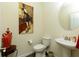 Elegant powder room featuring a pedestal sink, decorative art, and modern fixtures at 200 Bexley Pkwy, Tyrone, GA 30290