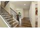 Well-lit staircase with hardwood steps and wrought iron railing leading to the upper level at 200 Bexley Pkwy, Tyrone, GA 30290