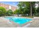 Community pool with pristine blue water, surrounded by mature trees and lounging chairs, perfect for a refreshing swim at 2965 Pharr Court South Nw # 712, Atlanta, GA 30305