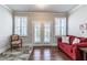 Comfortable sitting room with a red sofa, French doors, plantation shutters, and hardwood floors at 407 After Glow Smt, Canton, GA 30114