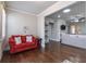 Sitting room featuring hardwood floors, a red sofa, and a view to the main living space and kitchen at 407 After Glow Smt, Canton, GA 30114