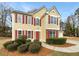 A charming two-story home with a red front door, red shutters and well-maintained landscaping at 380 Birchmere Sw, Atlanta, GA 30331