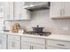 Close-up of kitchen details: herringbone backsplash, stainless hood, and cooktop at 5955 Misty Hill Ln, Buford, GA 30518