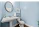 Light blue powder room with pedestal sink, hardwood floors, and chrome finishes at 2207 Derbyshire Sw Dr, Marietta, GA 30064