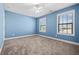 Bright bedroom featuring blue colored walls, modern light fixtures, and two windows for natural light at 2207 Derbyshire Sw Dr, Marietta, GA 30064