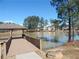 Enjoy tranquil lake views from the wooden community dock on a sunny day near mature trees at 2207 Derbyshire Sw Dr, Marietta, GA 30064