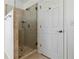 Tiled walk-in shower with glass door next to a standard-size interior door at 2395 Saint James Nw Dr, Atlanta, GA 30318