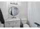 Powder room with marble countertop vanity, modern lighting, and a round mirror at 381 Gates Mil Dr, Lawrenceville, GA 30045