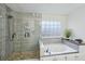 Modern bathroom features a glass enclosed shower and a jacuzzi tub at 381 Gates Mil Dr, Lawrenceville, GA 30045