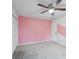 Cozy bedroom featuring a ceiling fan, neutral wall with a pink stripe, and carpet floors at 381 Gates Mil Dr, Lawrenceville, GA 30045