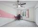 Well-lit bedroom featuring a neutral wall with a pink stripe, a ceiling fan, and carpet floors at 381 Gates Mil Dr, Lawrenceville, GA 30045