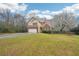 Well-kept home featuring a two-car garage, green lawn, and a brick and tan exterior at 381 Gates Mil Dr, Lawrenceville, GA 30045