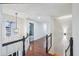 Upstairs hallway with hardwood flooring, overhead lighting, and black and white railing at 381 Gates Mil Dr, Lawrenceville, GA 30045