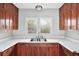 Close-up of kitchen sink, features stainless fixtures with white countertops and wood cabinetry at 2122 Kimberly Sw Rd, Atlanta, GA 30331