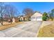 View of the home's front yard with a long driveway leading to a two-car garage, complemented by mature trees at 3710 Glen Ian Dr, Loganville, GA 30052