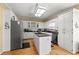 Spacious kitchen with white cabinetry, stainless steel appliances, an island and hardwood floors at 3710 Glen Ian Dr, Loganville, GA 30052