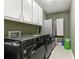 This laundry room features built-in cabinets, neutral walls, and modern washer and dryer at 3710 Glen Ian Dr, Loganville, GA 30052
