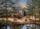 View of backyard with waterfront pergola swing, deck with stairs, and brick exterior at 1320 Kildare Ct, Snellville, GA 30078