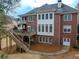 Expansive backyard with a deck, patio, and lush landscaping surrounding a beautiful brick home at 1320 Kildare Ct, Snellville, GA 30078