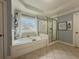 Bathroom featuring a large tub, large window, and shower offering comfort and style at 1320 Kildare Ct, Snellville, GA 30078
