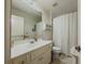 Bright bathroom features vanity and mirror, toilet, and bathtub with shower curtain at 1320 Kildare Ct, Snellville, GA 30078