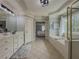 Bright bathroom features a soaking tub with tiled flooring, and a large white vanity with framed mirror at 1320 Kildare Ct, Snellville, GA 30078