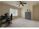 Carpeted bedroom featuring a ceiling fan, window, and study/gaming desk setup at 1320 Kildare Ct, Snellville, GA 30078