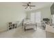 Cozy bedroom with natural light, featuring a wrought iron bed, ceiling fan, and neutral decor at 1320 Kildare Ct, Snellville, GA 30078