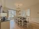 Dining room featuring a large table, chandelier, hardwood floors, and abundant natural light from a large window at 1320 Kildare Ct, Snellville, GA 30078