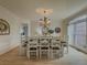 Open-concept dining room with a large table set for ten, decorative chandelier, and hardwood floors at 1320 Kildare Ct, Snellville, GA 30078