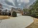 Spacious driveway leading to a three-car garage, adjacent to a manicured lawn and treelined property at 1320 Kildare Ct, Snellville, GA 30078