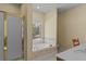Bathroom featuring a soaking tub with tile surround, a shower, and a window at 2148 Ne Indian Shoals Dr, Loganville, GA 30052