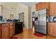 Bright kitchen with stainless steel refrigerator, wooden cabinets, granite countertops, and hardwood flooring at 2148 Ne Indian Shoals Dr, Loganville, GA 30052
