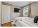 Cozy bedroom featuring hardwood floors, a window with blinds, and a mounted TV at 2350 Brenda Se Dr, Smyrna, GA 30080