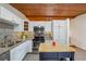 Well-lit kitchen with stainless steel appliances, granite countertops, and white cabinets under a wood-paneled ceiling at 2350 Brenda Se Dr, Smyrna, GA 30080