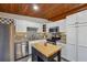 Bright kitchen featuring granite countertops, stainless steel appliances, white cabinetry, and a wood-paneled ceiling at 2350 Brenda Se Dr, Smyrna, GA 30080