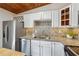 Modern kitchen with stainless steel appliances, granite countertops, and white cabinets, with a wood-paneled ceiling at 2350 Brenda Se Dr, Smyrna, GA 30080