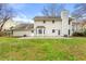 View of a backyard and exterior of the house with a large lawn and patio area at 5215 Willow Creek Overlook, Woodstock, GA 30188