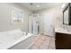This bathroom includes a soaking tub, tiled floors, walk-in shower, and a double vanity at 5215 Willow Creek Overlook, Woodstock, GA 30188